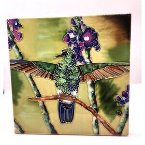 hand-painted or mosaic ceramic tile featuring a hummingbird and flowers.